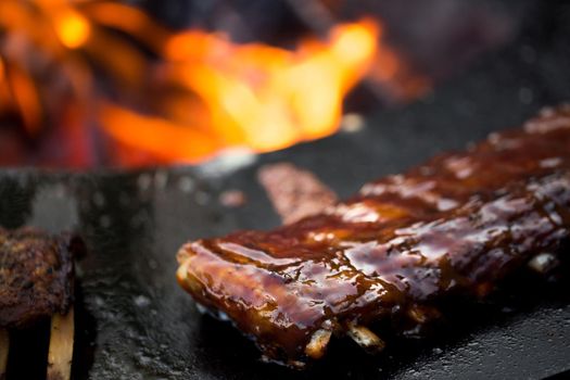 Grilled pork baby ribs with barbecue sauce on the grill. Festival street food