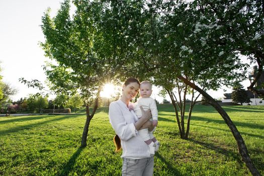 Beautiful Mother And Baby outdoors. Nature. Beauty Mum and her Child playing in Park