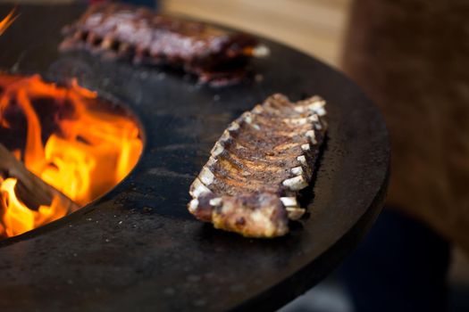 Grilled pork baby ribs with barbecue sauce on the grill. Festival street food