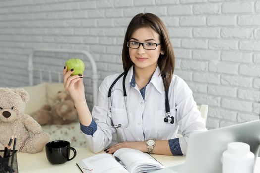Portert smiling medical doctor woman with apple