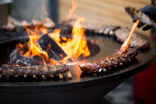 Grilled pork baby ribs with barbecue sauce on the grill. Festival street food