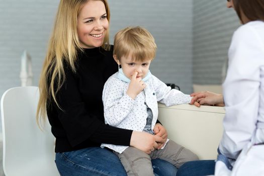 A boy picks his nose at a doctor's appointment