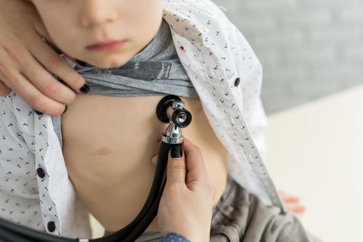 Professional general medical pediatrician doctor in white uniform gown listen lung and heart sound of child patient with stethoscope.