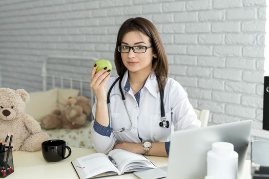 Portert smiling medical doctor woman with apple