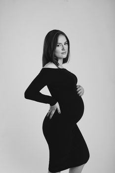 Black and white photo of a pregnant woman on a white background. Silhouette.