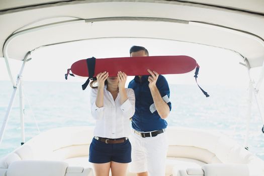 A man and a woman on a yacht with a lifebuoy.