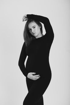 Black and white photo of a pregnant woman on a white background. Silhouette.