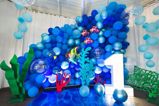 Marine-style decor of balloons, fish, and corals for the birthday photo zone.