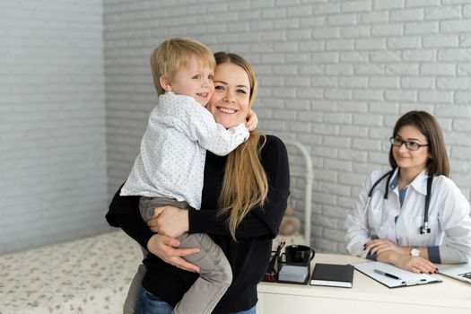 Portrait of mother and child at a doctor's appointment. Pediatrician meeting with mother and child in hospital.