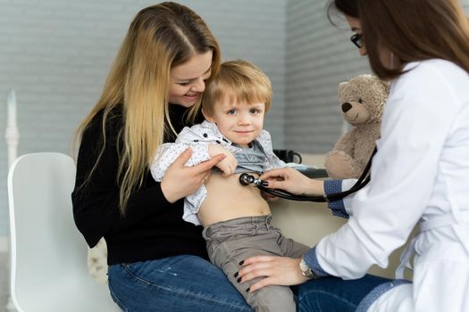 Professional general medical pediatrician doctor in white uniform gown listen lung and heart sound of child patient with stethoscope: Physician check up kid female after consult in hospital