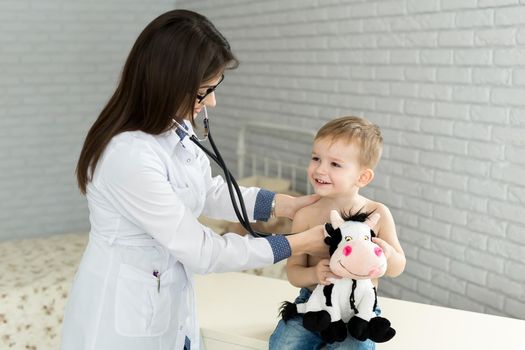 Professional general medical pediatrician doctor in white uniform gown listen lung and heart sound of child patient with stethoscope.