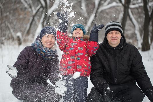 Parents with son play with the snow