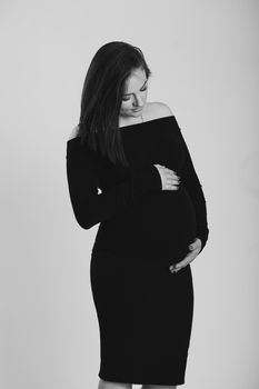 Black and white photo of a pregnant woman on a white background. Silhouette.