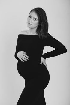 Black and white photo of a pregnant woman on a white background. Silhouette.