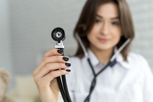 Medical doctor woman holding a stethoscope focus on the stethoscope