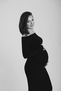 Black and white photo of a pregnant woman on a white background. Silhouette.