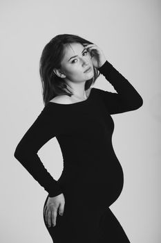 Black and white photo of a pregnant woman on a white background. Silhouette.