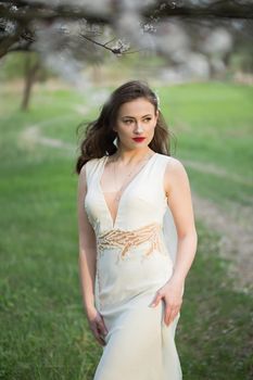 The bride in the green forest poses at sunset