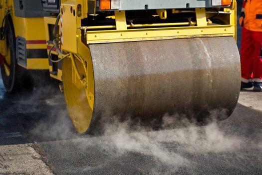 Road repairs. Compact steamroller flatten out the asphalt