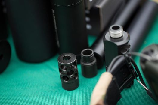 silencers for weapons are on the green table