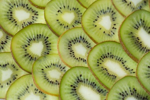 Bright green background with slices of juicy kiwi. Healthy food background.