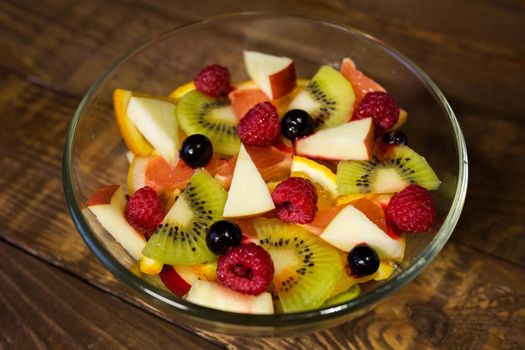 Delicious fruits salad in plate on table close-up