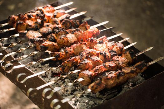 Marinated shashlik preparing on a barbecue grill over charcoal. Shashlik or Shish kebab popular in Eastern Europe. Shashlyk skewered meat was originally made of lamb. Roast Beef Kebabs On BBQ Grill.