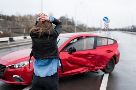 Woman stands near a broken car after an accident. call for help. car insurance