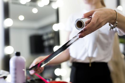 Barber holds the foil for hair coloring