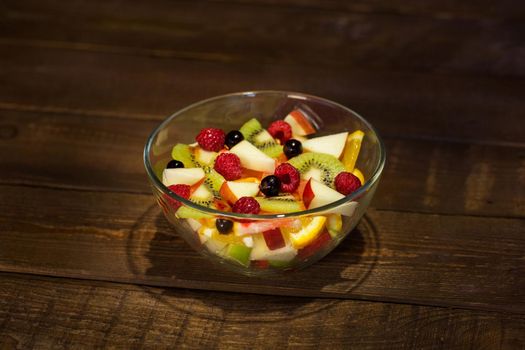 Delicious fruits salad in plate on table close-up