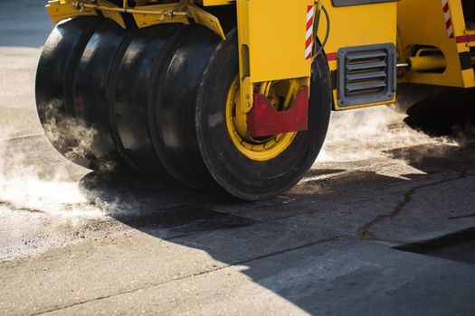 Road repairs. A road roller compacting asphalt