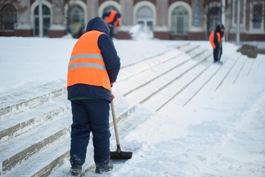 Workers sweep snow from road in winter, Cleaning road from snow storm.