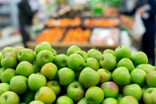 Green apples on boxes in supermarket