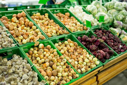 Onions and garlic on the supermarket shelf vegetable