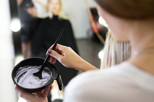 paint with a brush in the hands of a hairdresser