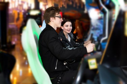 Man and woman play on the slot machines, attractions in the shopping center