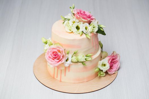 Tiered cake with fresh flowers and macaroons