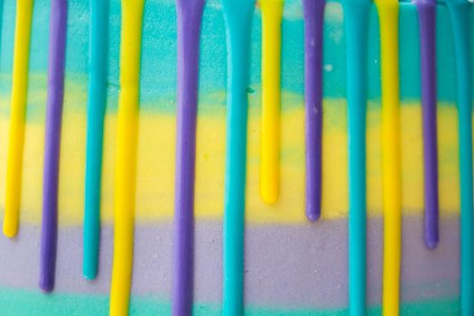 Chocolate drops on a striped cake close-up.