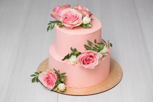 Delicate pink wedding cake with fresh flowers.