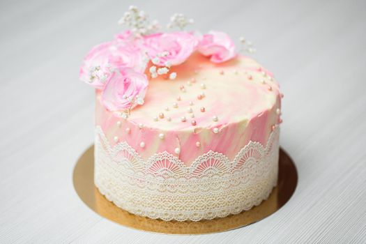 Delicate pink cake with pearls and waffle flowers.