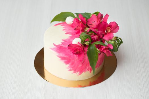 Cake with pink chocolate decor and flowers.