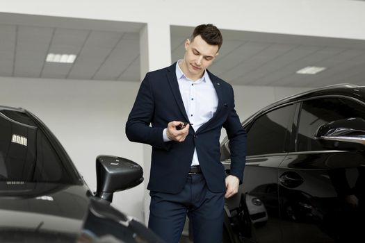 Handsome man choosing a car in a show room