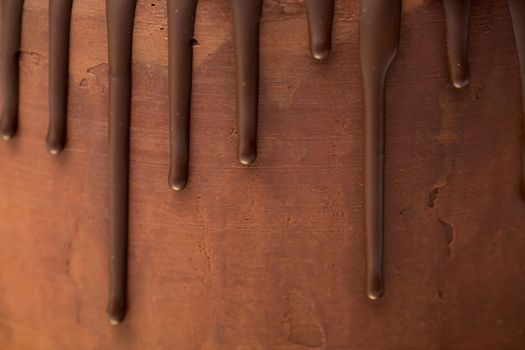 chocolate drips on the background of dark chocolate ganache