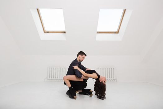 beautiful couple dancing bachata on white background in studio