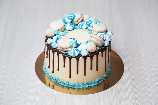 Cake with chocolate streaks, blue meringue and macaroons