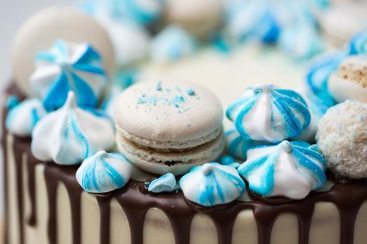 Cake with chocolate streaks, blue meringue and macaroons