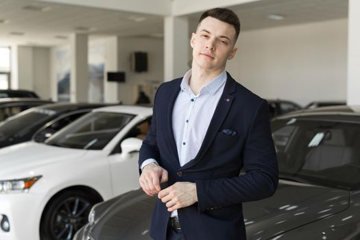 Handsome man choosing a car in a show room