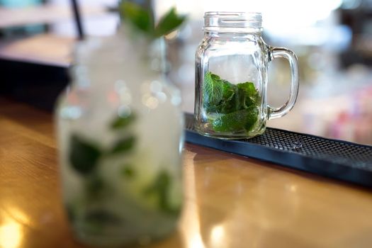 Mojito cocktail in a glass on the bar close-up.