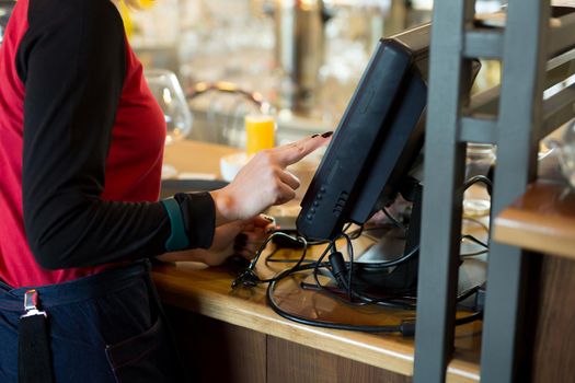 A waiter of a modern cafe or bar enters an order or payment via a tablet or a seekipper.