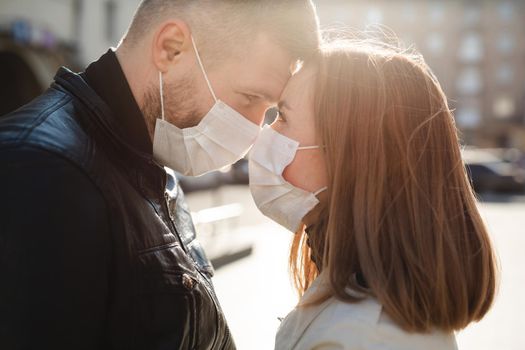 Couple in love, man and woman kissing each other in protective medical mask on face. Guy, girl against pandemic coronavirus, virus protection. Covid19.